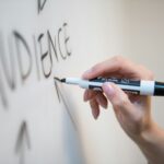 personne tenant un stylo à clic blanc et bleu