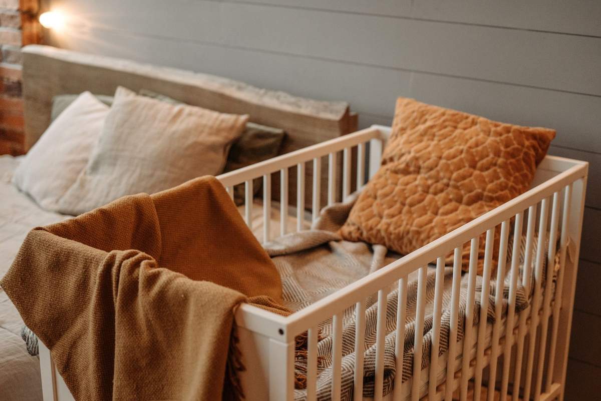 Lit blanc avec plaids et coussins dans une chambre Lit blanc avec plaids et coussins dans une chambre