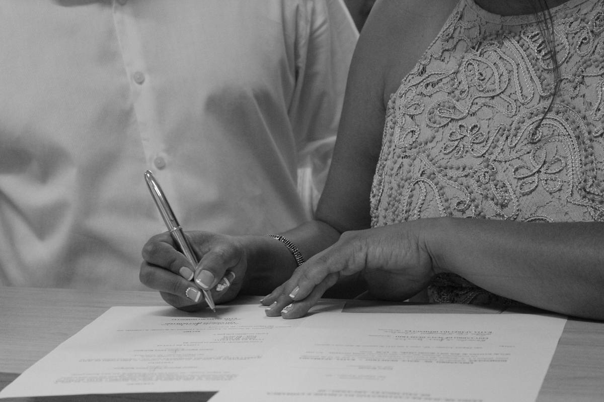 Femme écrivant sur un papier avec un stylo, une autre personne à côté