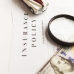 Assurance policy, magnifying glass, toy car, dollar bills, document review