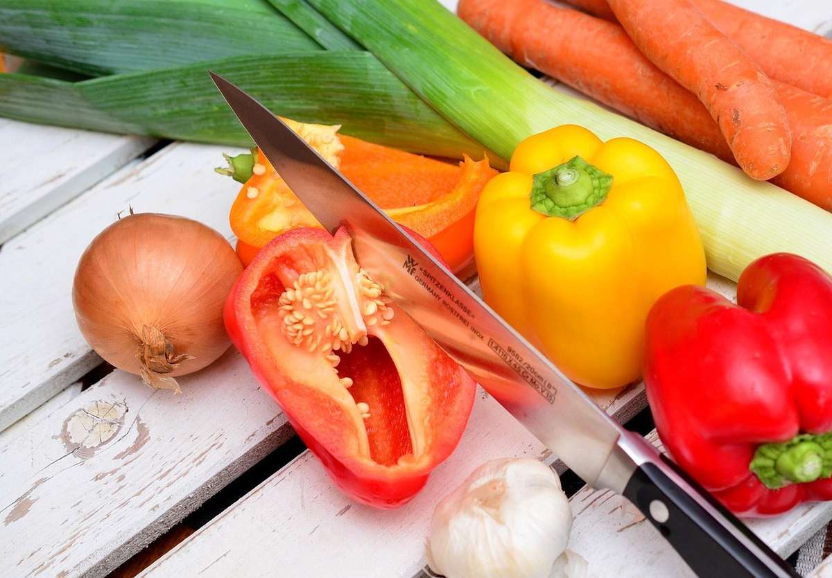 Légumes et fruits sur une table blanche, couteau, activité de préparation culinaire Légumes et fruits sur une table blanche, couteau, activité de préparation culinaire