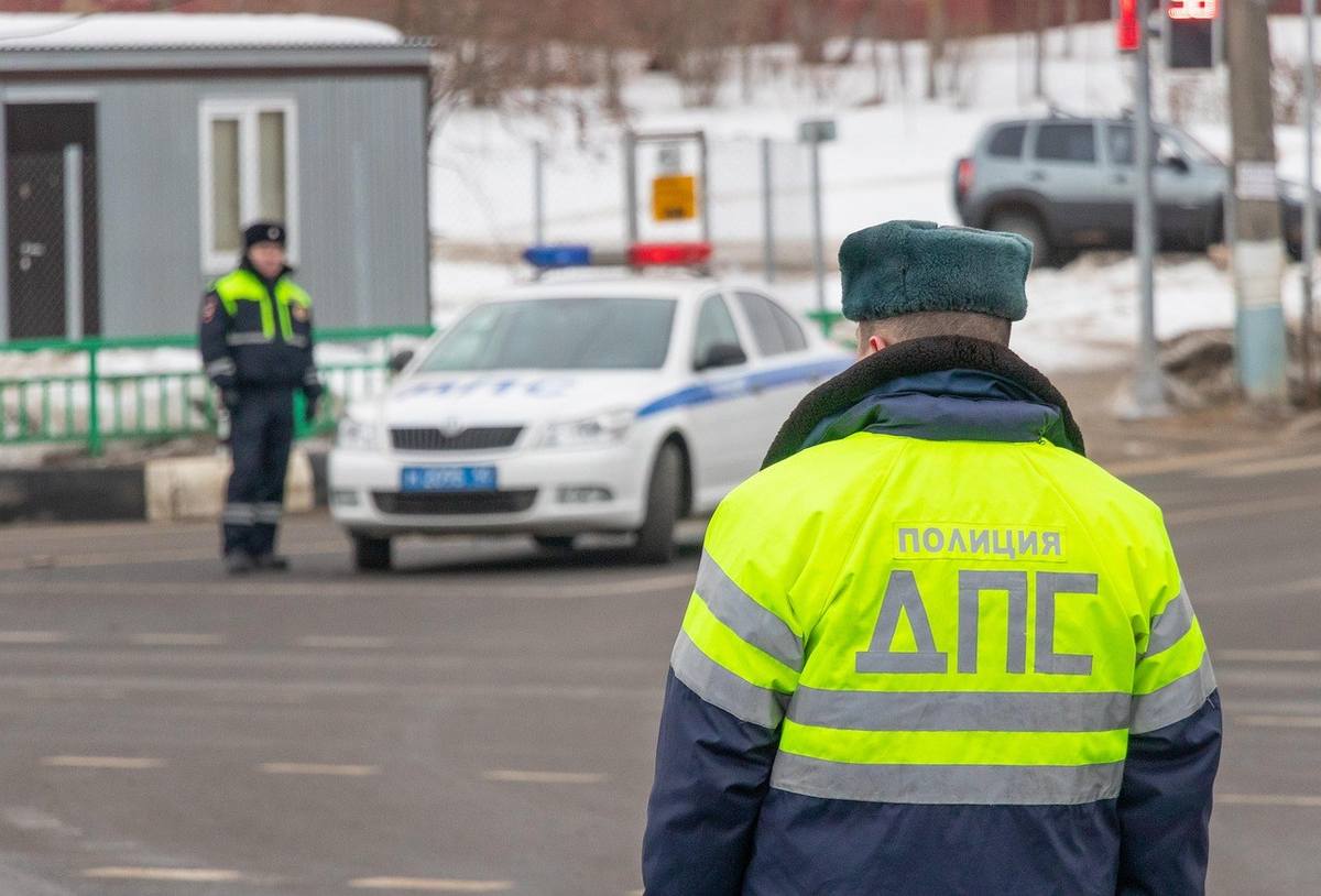 Agents de police en gilet jaune, véhicule de patrouille, intersection hivernale