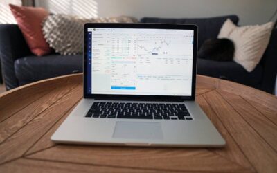 Laptop sur table en bois dans un salon avec canapé et coussins