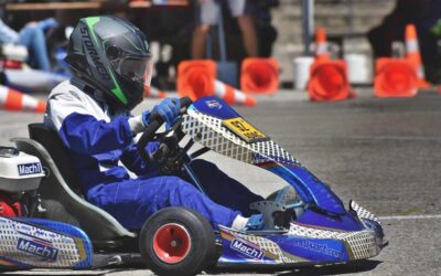 Un pilote en combinaison bleue conduit un kart de course