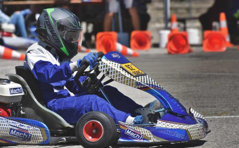Un pilote en combinaison bleue conduit un kart de course
